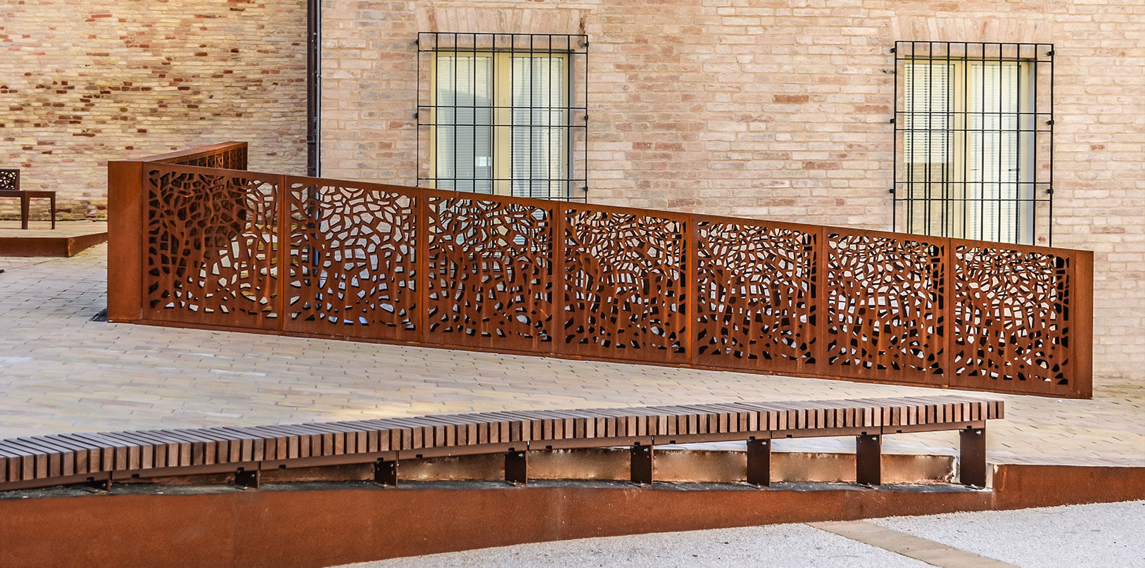 ramp delimited by a laser engraved steel railing and corten borders